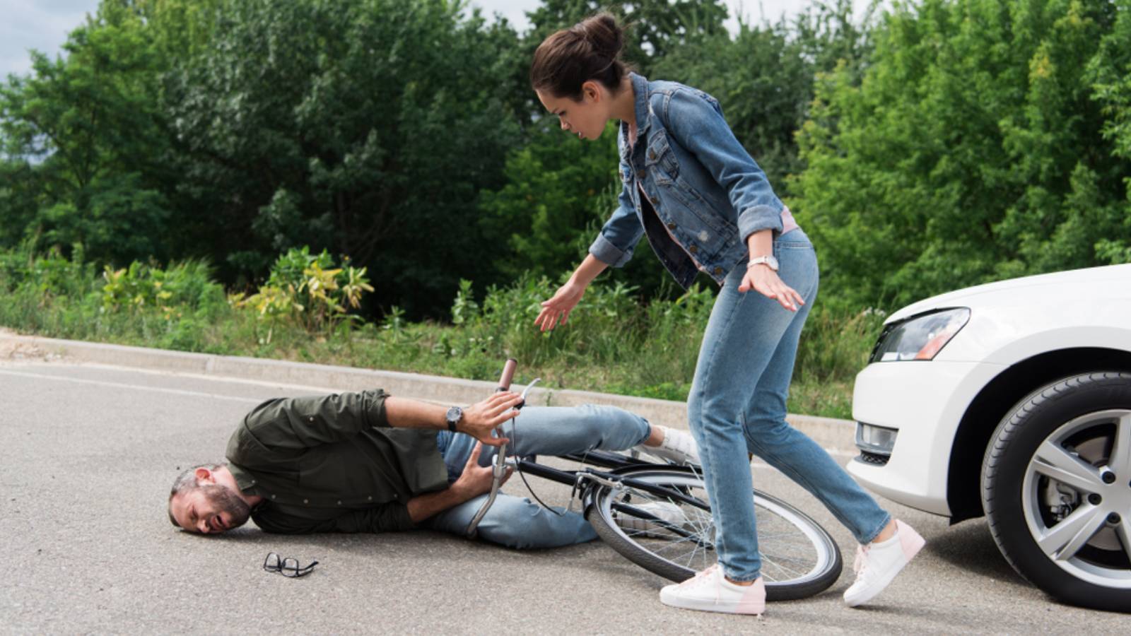 driver walking to biker after car accident on road